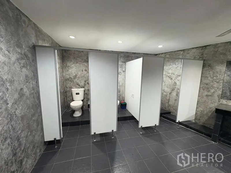 Office Space for rent in Khlong Toei, Bangkok - Large tiled washroom with multiple private toilet cubicles.