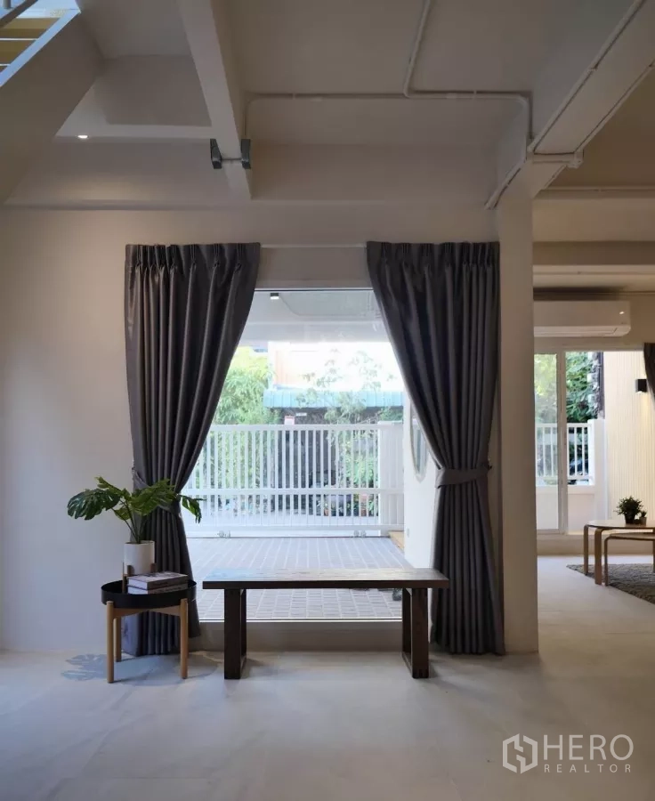 Townhouse for rent or sale in Watthana, Bangkok - Entrance nook with dark curtains framing the view to the gated courtyard.