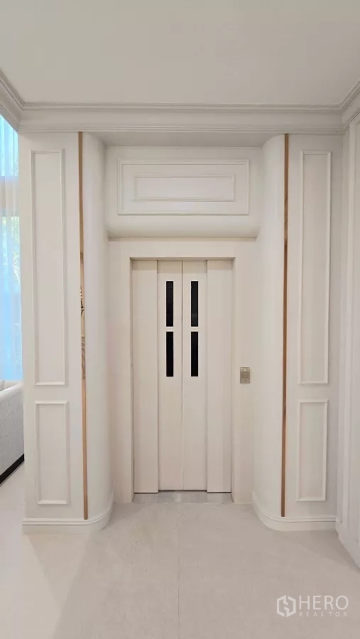Detached House for rent in Prawet, Bangkok - Private home elevator doors set within white paneled walls.
