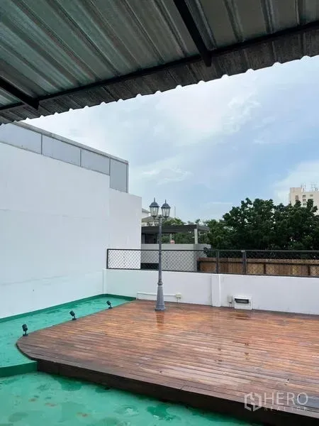 联排别墅 出租在Phaya Thai, Bangkok - 屋顶露台，抬高木平台、部分遮棚与开阔城市景观。