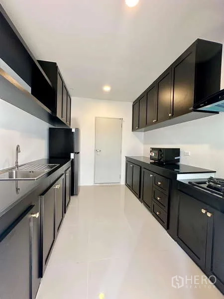 Detached House for rent in Bang Phli, Samut Prakan - Modern kitchen view showing ample counter space, upper cabinets and appliances.