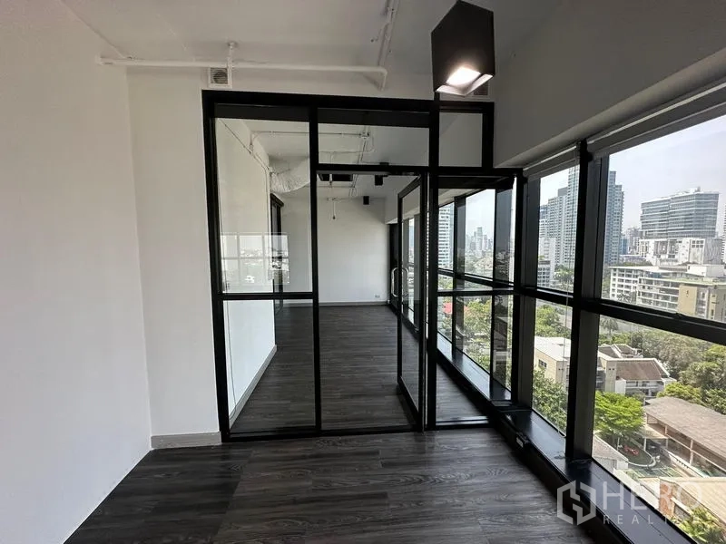 Office Space for rent - Corner private office with black-framed glass walls and city views.