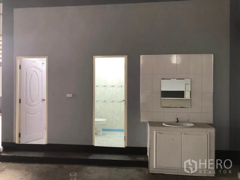 Factory for rent in Bang Len, Nakhon Pathom - Warehouse restroom zone with two white doors and a vanity sink.