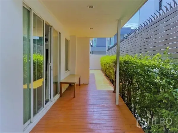 Detached House for rent in Suan Luang, Bangkok - Covered side wooden deck with sliding glass doors and trimmed hedge for privacy.