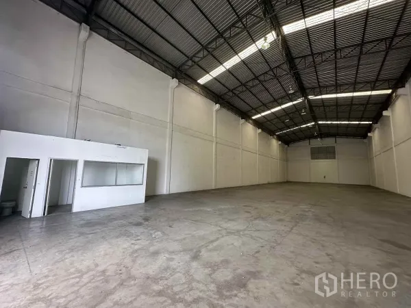 Warehouse for rent in Bang Pa-in, Phra Nakhon Si Ayutthaya - High-ceiling warehouse interior with steel truss roof, polished concrete floor, and built-in office and toilet.