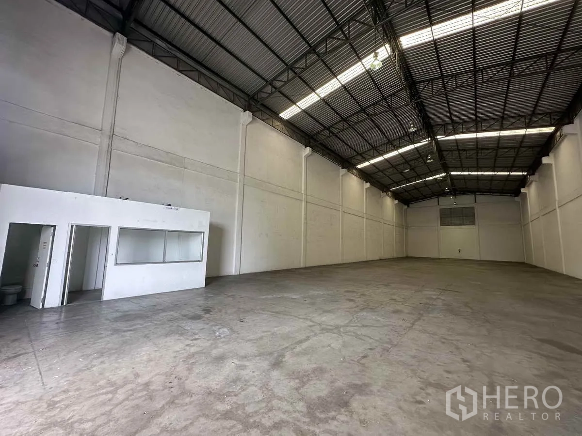 Warehouse for rent in Bang Pa-in, Phra Nakhon Si Ayutthaya - High-ceiling warehouse interior with steel truss roof, polished concrete floor, and built-in office and toilet.
