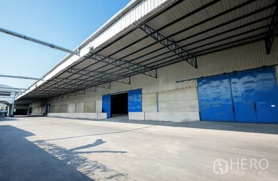货栈 出租在Pathum Thani - 仓库长立面配多处装卸口及宽阔卡车通道。