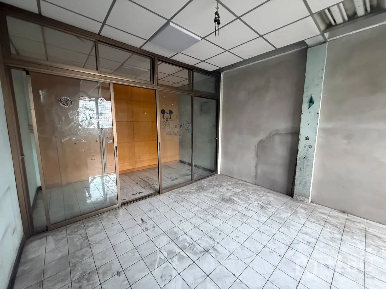 Shophouse for rent in Khlong Toei, Bangkok - Glass-partitioned room with tiled floor and suspended ceiling panels.