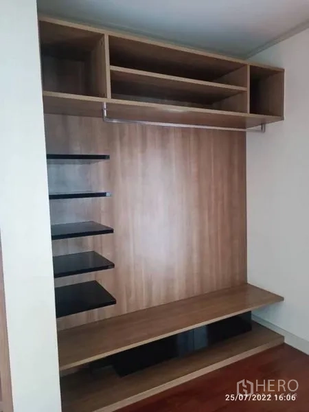 Detached House for sale in Prawet, Bangkok - Open wardrobe unit with shelves and hanging rail in a wood finish.