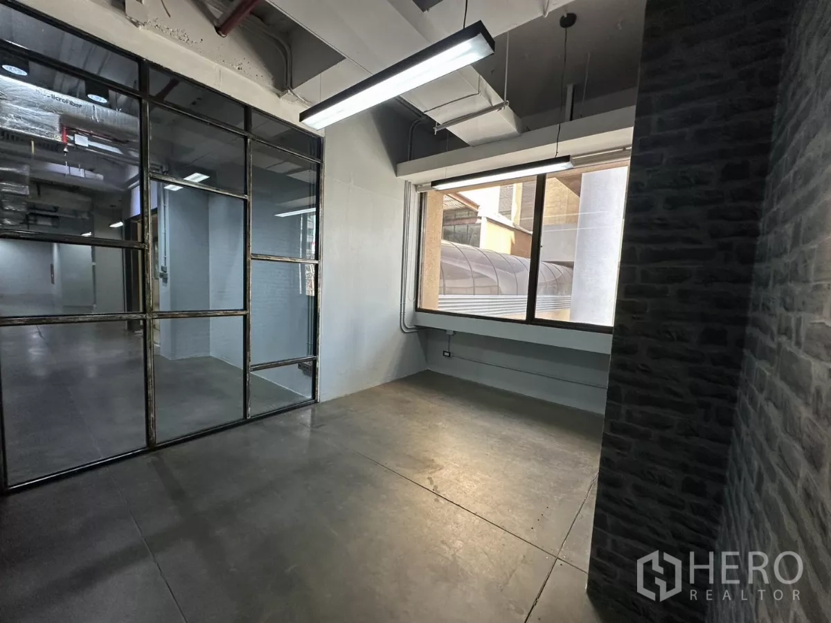 Office Space for rent - Compact office nook with glass wall and exterior window.