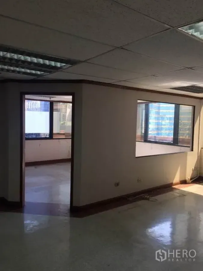 Office Space for rent in Watthana, Bangkok - Partitioned office area with large windows, fluorescent ceiling lights, and city outlook.