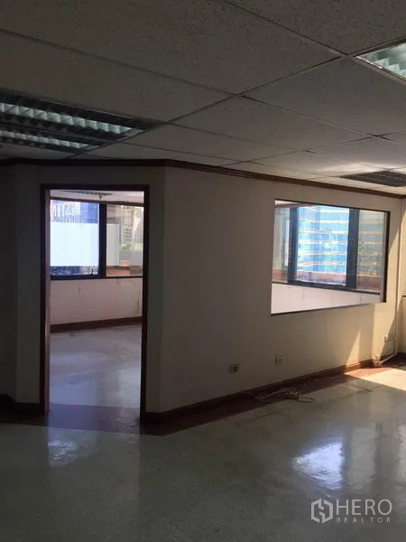 Office Space for rent in Watthana, Bangkok - Partitioned office area with large windows, fluorescent ceiling lights, and city outlook.