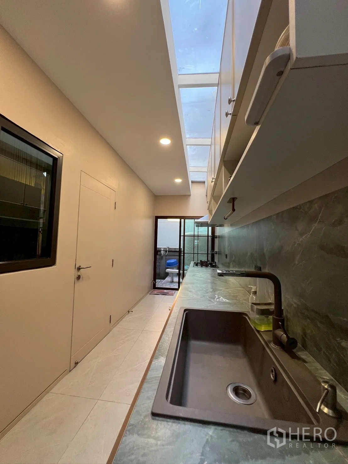 Detached House for rent in Bang Kapi, Bangkok - Service kitchen with long countertop, sink, and skylight ceiling.