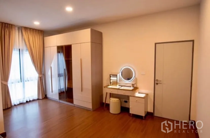 Detached House for rent in Bang Phli, Samut Prakan - Large bedroom with wardrobe and lighted vanity set.