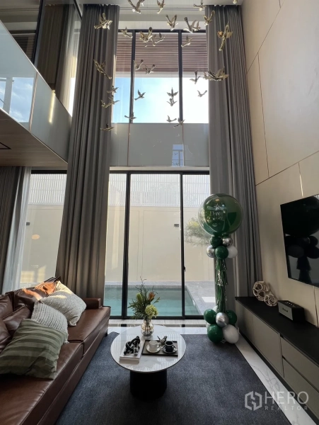 Detached House for sale in Lat Phrao, Bangkok - Living area opening to a private lap pool through floor-to-ceiling sliding glass doors.