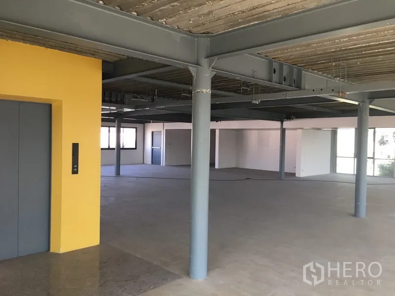 Warehouse for rent in Saphan Sung, Bangkok - Open-plan office floor with steel columns, elevator core and large windows.
