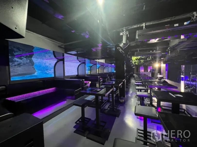 Retail Space for rent in Watthana, Bangkok - Booth seating and a wide LED wall facing dining tables in a dark contemporary space.