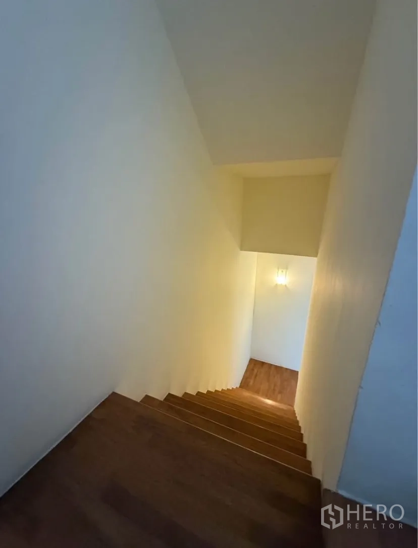 Townhouse for rent in Suan Luang, Bangkok - Staircase descending to lower floor with wall light.
