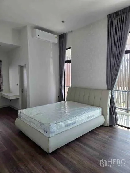 独立式住宅 出租在Bang Phli, Samut Prakan - 卧室配软包床、高窗与灰色窗帘。