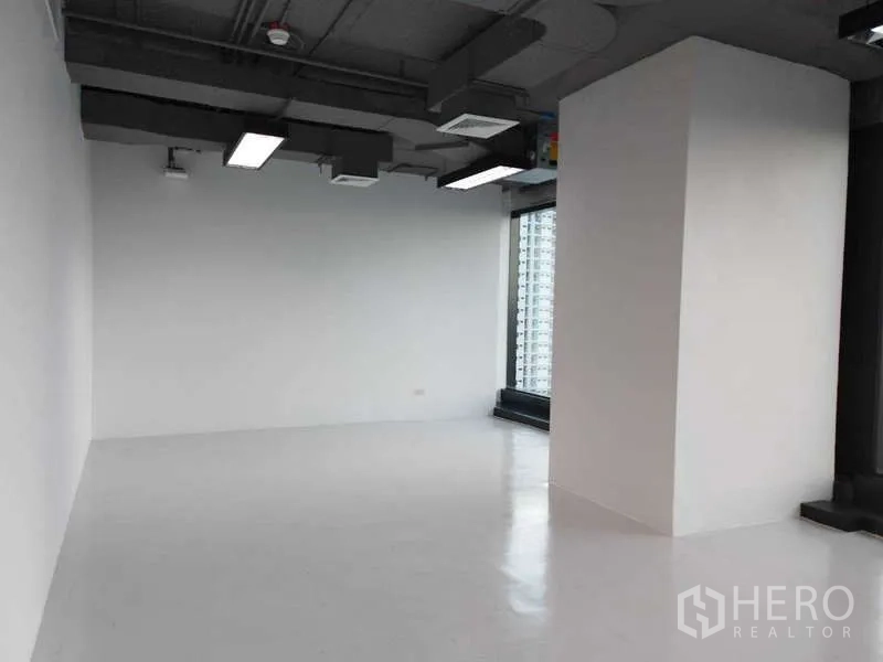 办公空间 出租 - 洁净工作区，抛光地面、承重柱与采光充足的窗户。