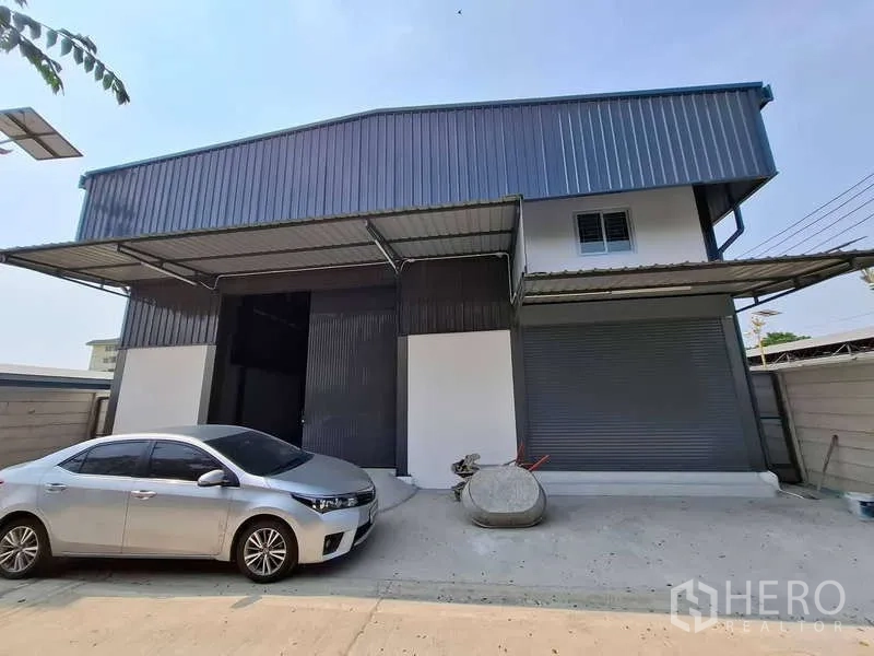 Warehouse for rent or sale in Bang Phli, Samut Prakan - Front elevation of warehouse with dual loading canopies and driveway.