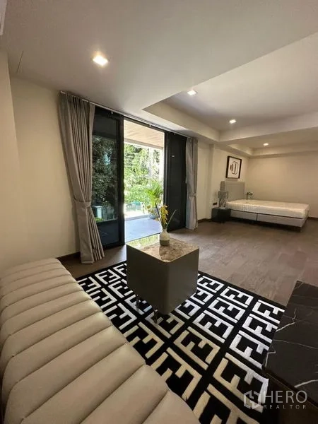 独立式住宅 出租在Suan Luang, Bangkok - 一层起居区，通过推拉门连接花园露台。