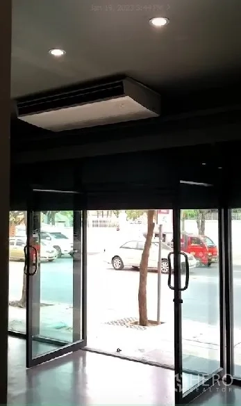 店屋 出租在Phra Khanong, Bangkok - 临街玻璃门头，双开玻璃门与吊顶柜式空调，面向人行道