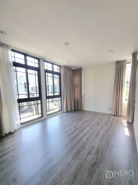 Detached House for rent - Large master bedroom with expansive corner windows, sheer curtains and laminate flooring.