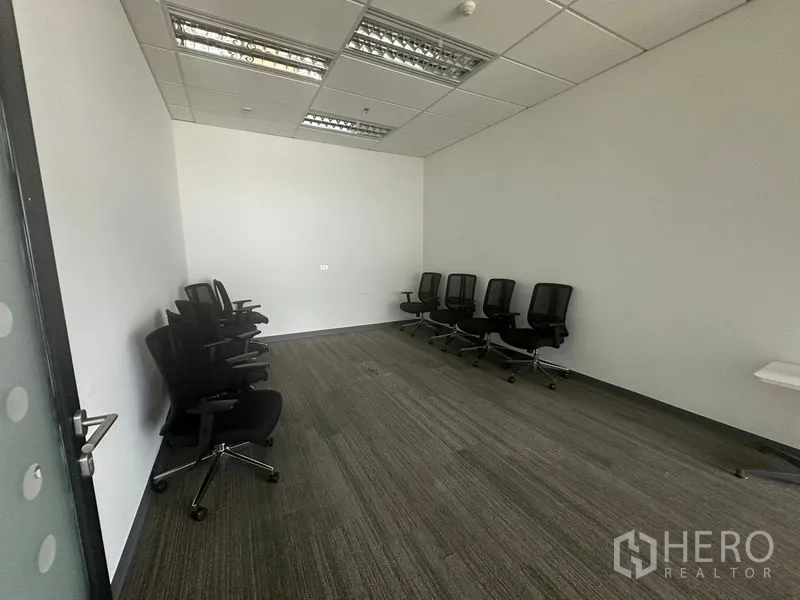 Office Space for rent in Ratchathewi, Bangkok - Empty training room with carpet tiles and lined chairs.