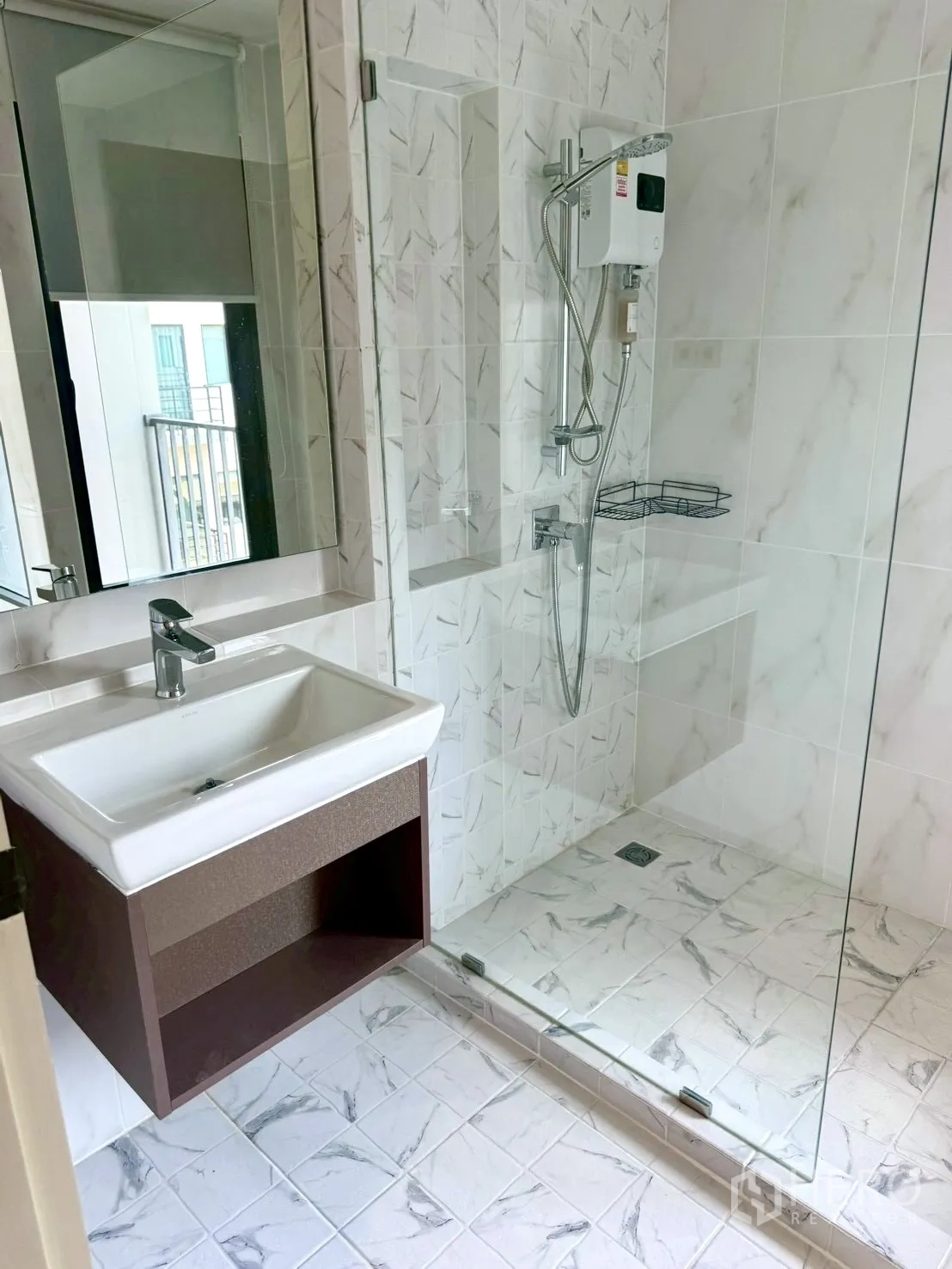 Townhouse for rent in Prawet, Bangkok - Bathroom with glass-enclosed shower, water heater, sink and mirror.
