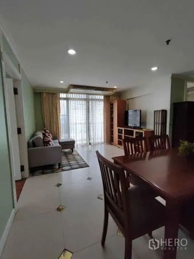 Condominium for rent or sale in Watthana, Bangkok - Living room facing balcony with TV unit, dining set and sliding glass doors