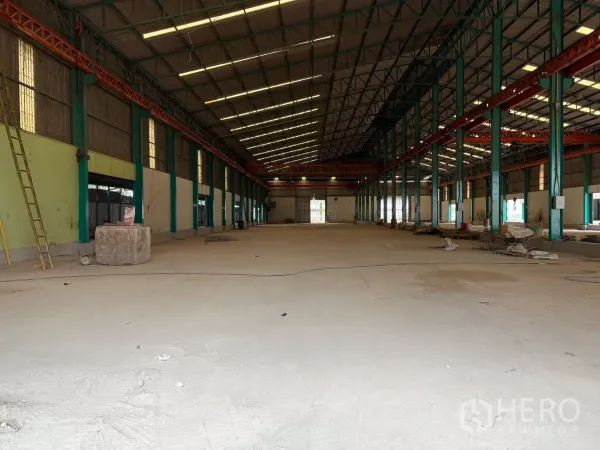 Factory for rent in Mueang Samut Sakhon, Samut Sakhon - Open-plan warehouse interior with multiple steel columns and overhead crane beams.
