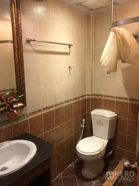 Shophouse for rent in Bang Rak, Bangkok - Tiled bathroom with toilet, countertop sink and handheld bidet.