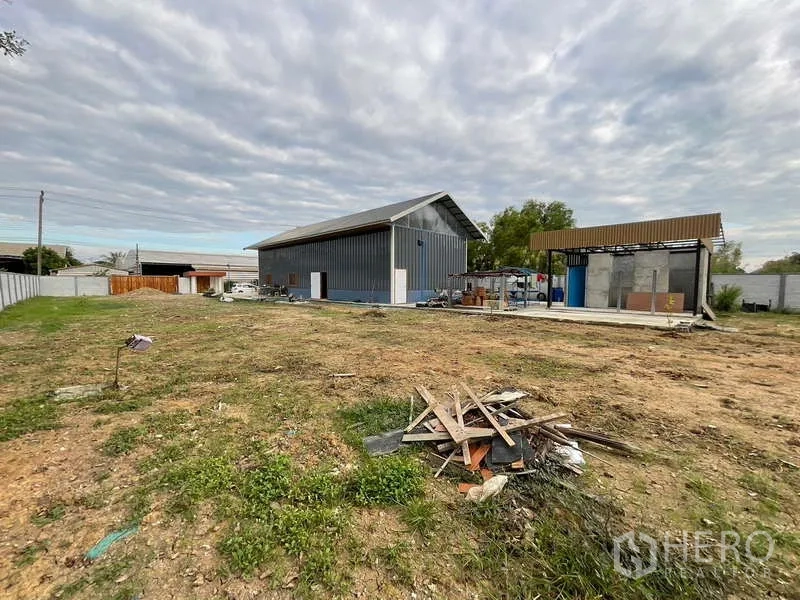 Warehouse for rent or sale in Nong Chok, Bangkok - Wide land plot showing warehouse and separate service pavilion set on a concrete base.