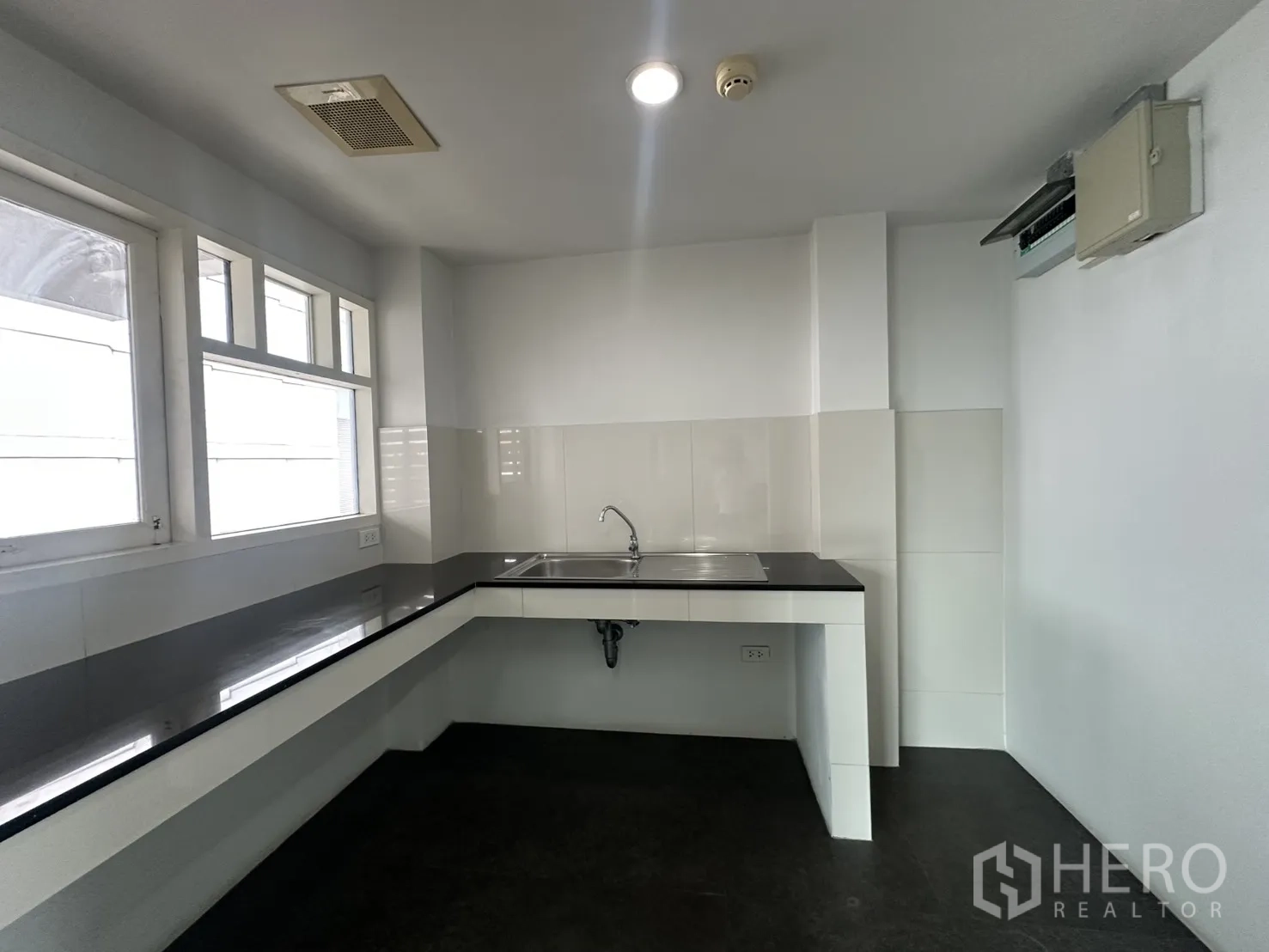 Office Space for rent in Watthana, Bangkok - Pantry area with long countertop, sink, and windows for natural light.