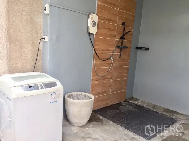 Townhouse for rent in Watthana, Bangkok - Outdoor laundry area with washing machine and exterior shower.