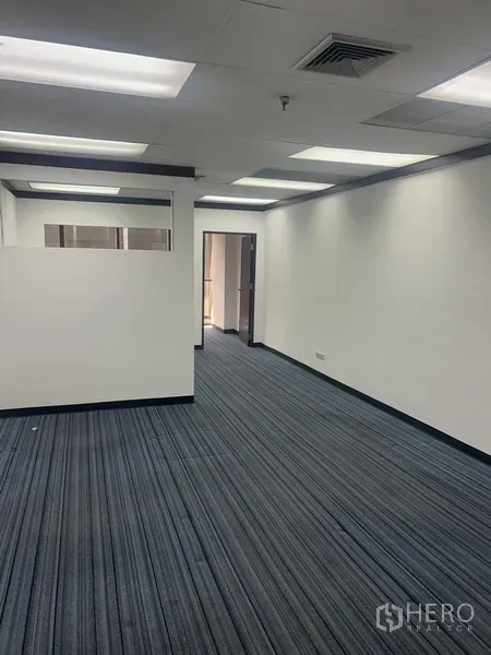 Office Space for rent in Pathum Wan, Bangkok - Open-plan 46 sqm office with striped carpet, white walls, drop-ceiling lights and a partial partition.