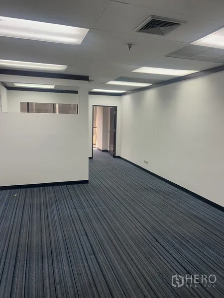 Office Space for rent in Pathum Wan, Bangkok - Open-plan 46 sqm office with striped carpet, white walls, drop-ceiling lights and a partial partition.