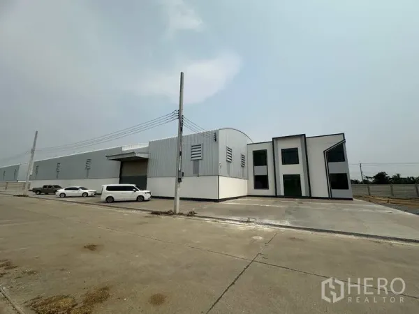 โรงงาน ให้เช่าหรือขายในSai Noi, Nonthaburi - ด้านหน้าโกดังยาวพร้อมบล็อกสำนักงานและที่จอดรถริมถนนอุตสาหกรรมกว้าง
