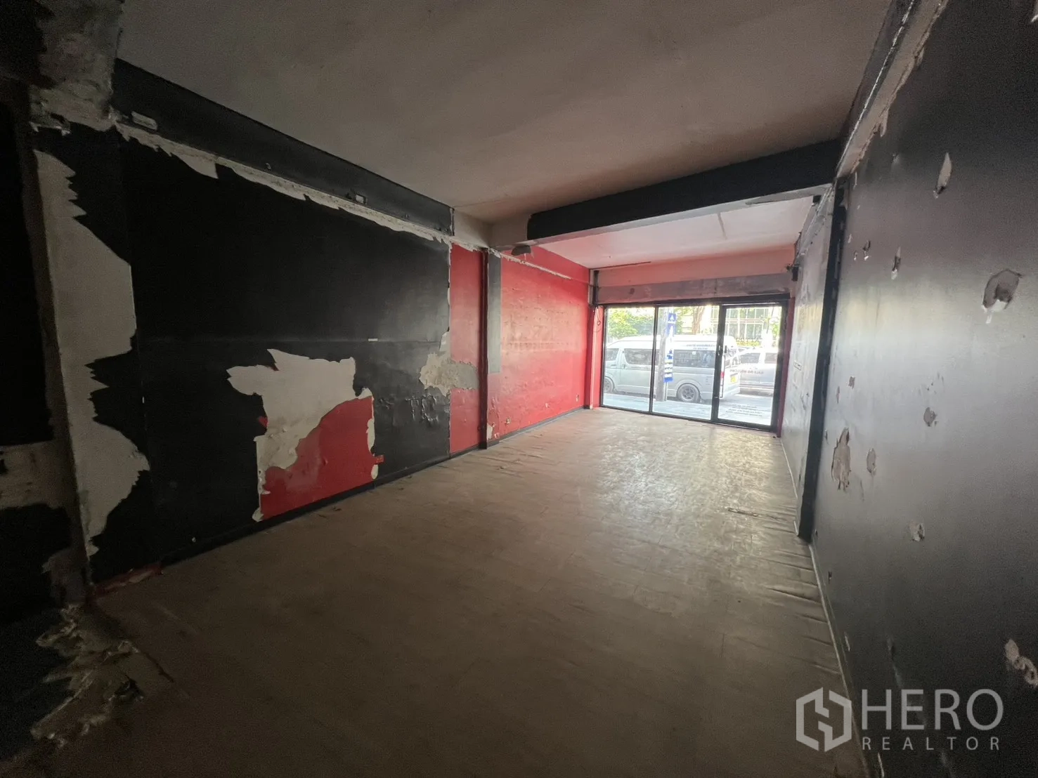 Shophouse for rent in Khlong Toei, Bangkok - Long narrow shop hall leading to sliding glass doors and street view in raw condition.