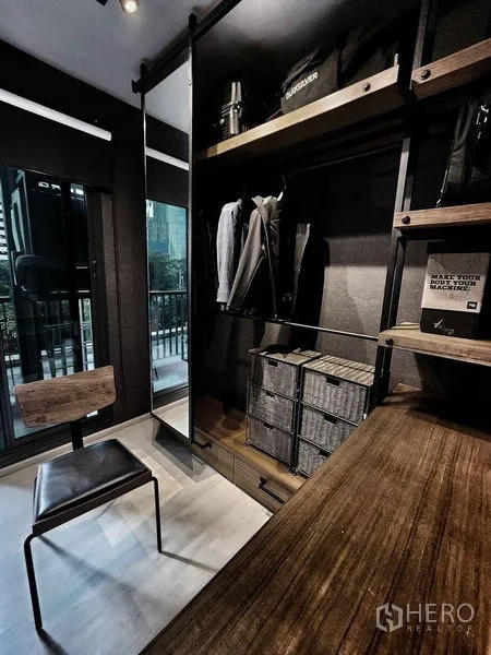 Condominium for sale in Pathum Wan, Bangkok - Open wardrobe with storage baskets and a work chair near the balcony.