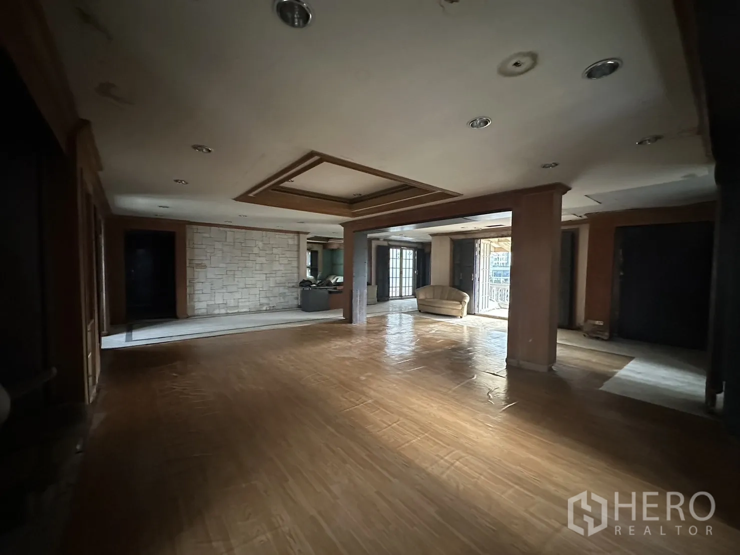 Home Office for rent in Huai Khwang, Bangkok - Large open workspace with feature ceiling, stone accent wall and ample daylight.