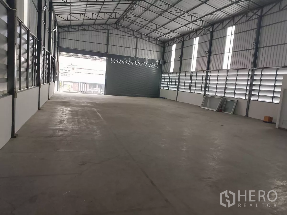 货栈 出租在Huai Khwang, Bangkok - 宽敞仓库内部，高挑人字形屋顶与百叶通风窗，朝向前门。