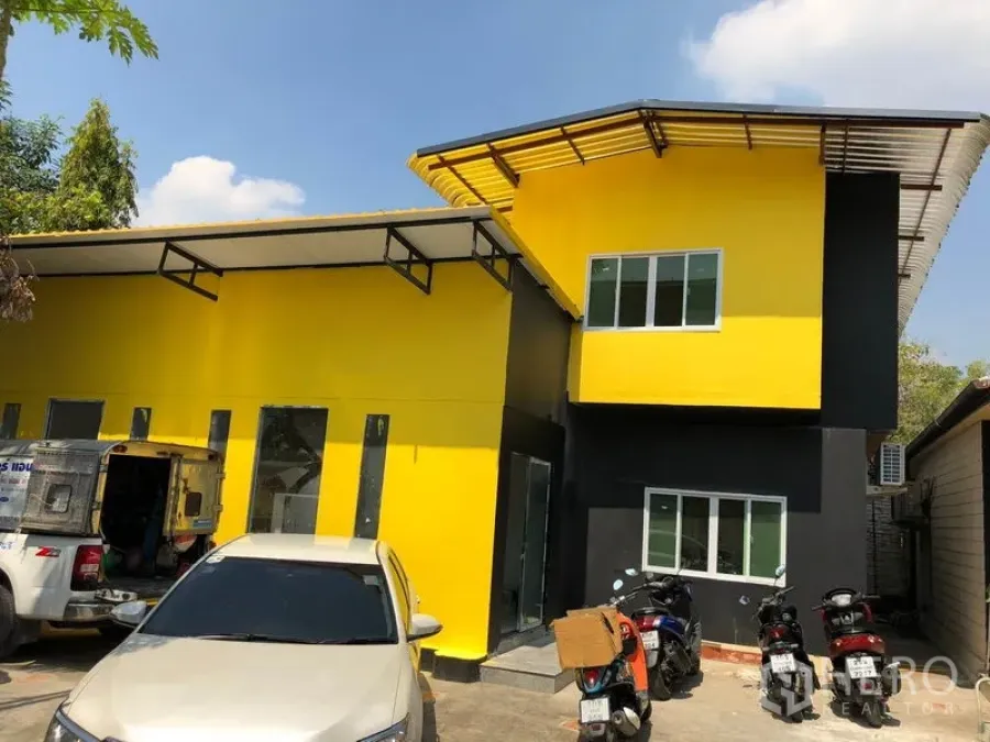 Detached House for sale in Khlong Toei, Bangkok - Two-storey yellow-and-black detached house with metal roof and on-site parking at the front.