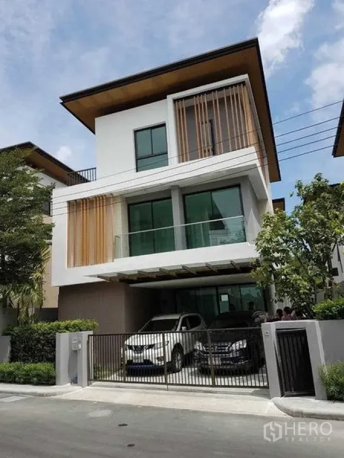 Detached House for rent in Prawet, Bangkok - Street view of a modern three-storey house with gated entrance and carport