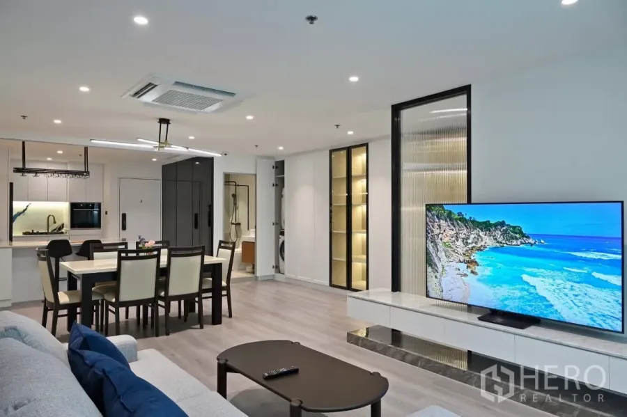 Condominium for rent in Watthana, Bangkok - Open-plan living and dining area at Sukhumvit Living Town condo with TV wall, built-in shelves and adjoining kitchen in Watthana, Bangkok.