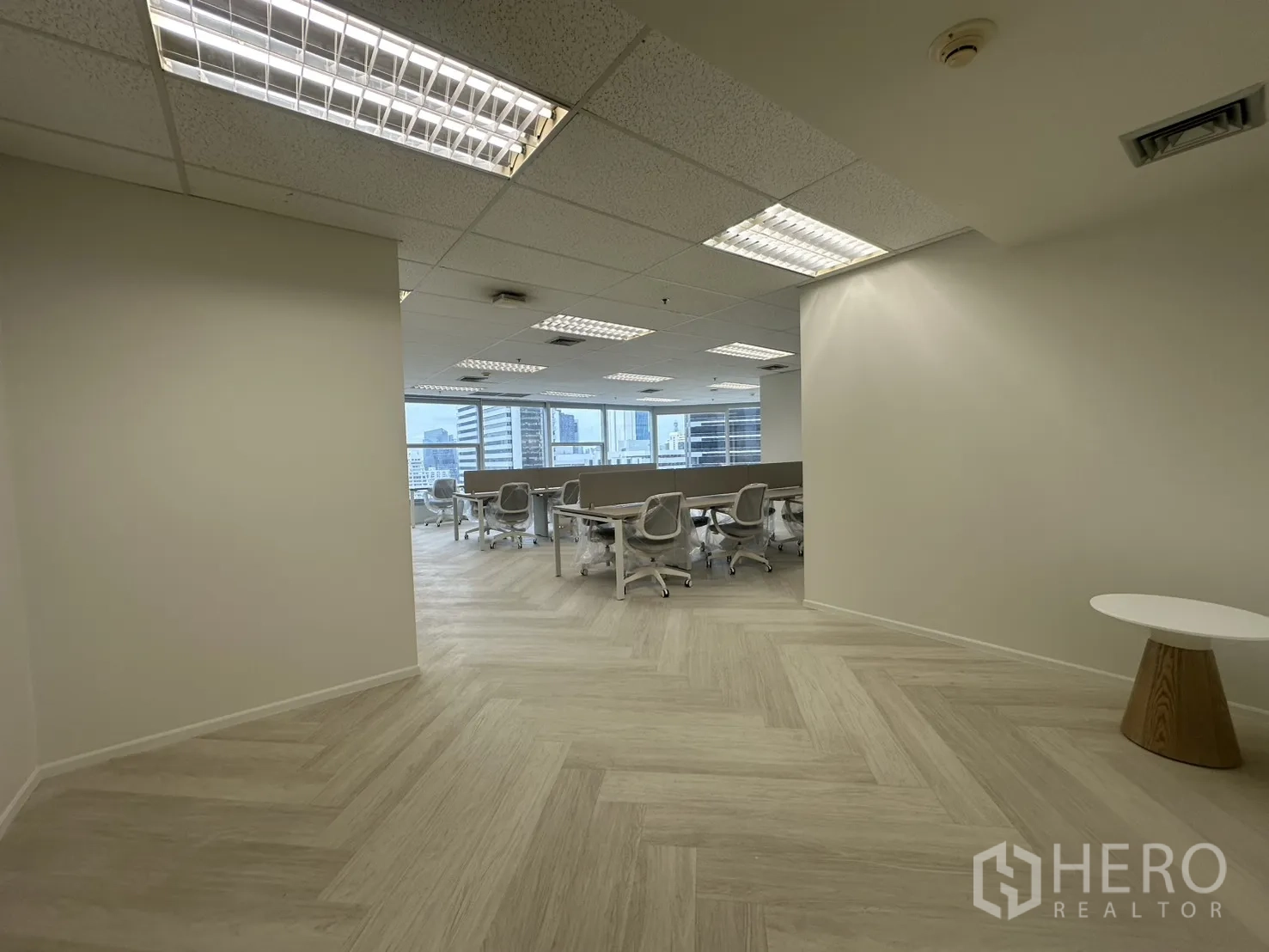 Office Space for rent in Sathon, Bangkok - Entry lounge leading to open workspace with herringbone light wood flooring and ceiling lights.