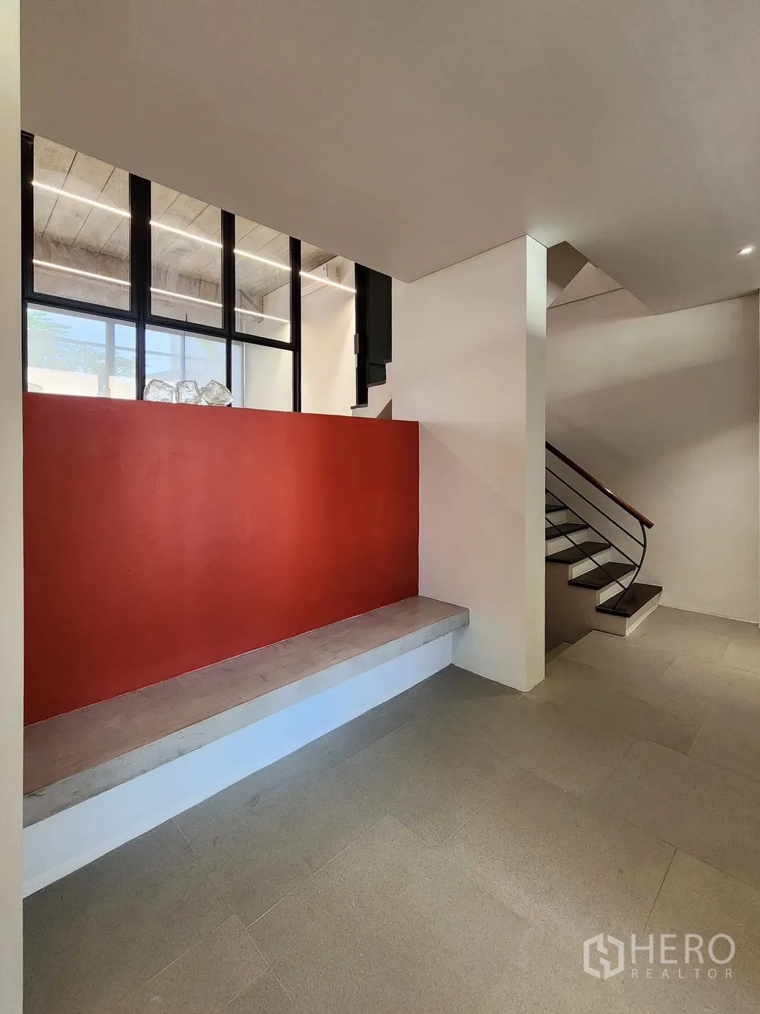 Home Office for rent in Chatuchak, Bangkok - Entrance lobby with built-in bench, red feature wall, and stairs to upper floors.