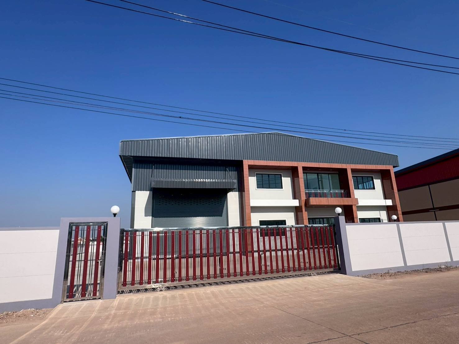 Factory for sale in Mueang Samut Sakhon, Samut Sakhon - Front elevation with sliding gate, perimeter wall and two-storey office facade.