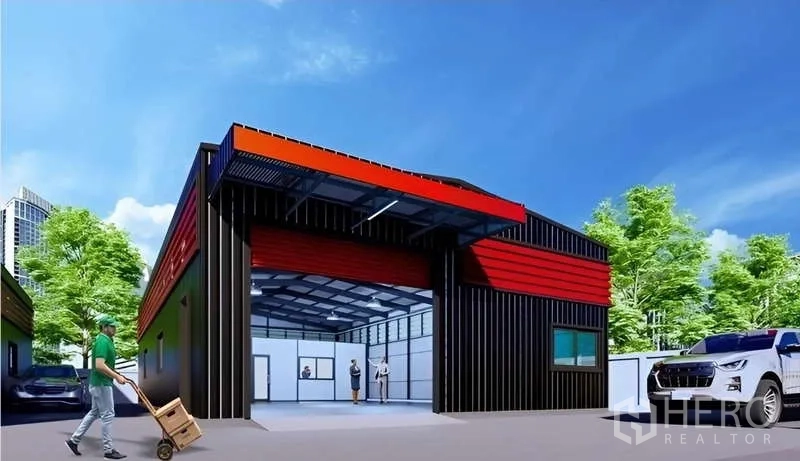 Warehouse for rent in Lat Phrao, Bangkok - Front view of the warehouse loading bay with open entrance, parking area, and greenery around the site.